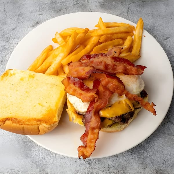 Dox burger with bacon, fried egg, cheese, and fries on a white plate.